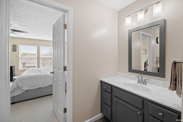bathroom featuring a textured ceiling, vanity, ceiling fan, baseboards, and connected bathroom