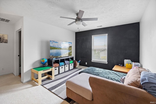 living area featuring carpet, a ceiling fan, a textured ceiling, and baseboards