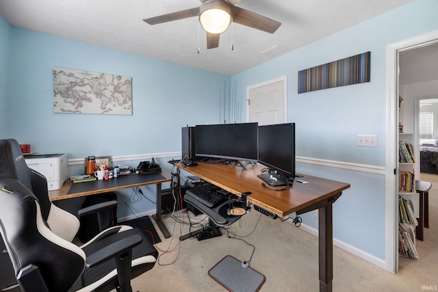 carpeted office with a ceiling fan and baseboards