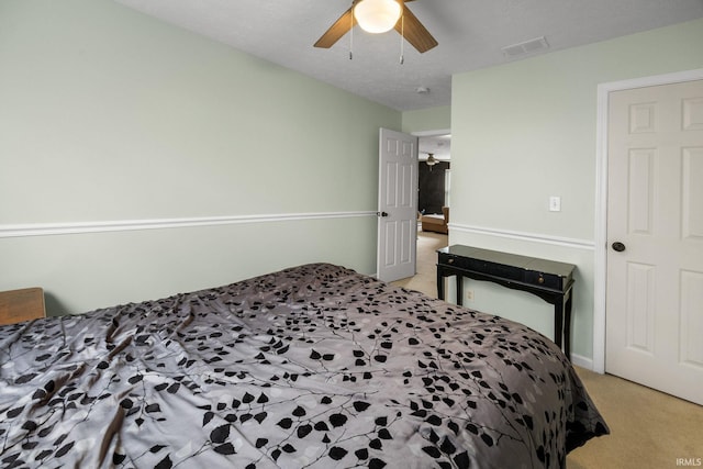 bedroom featuring light colored carpet and a ceiling fan