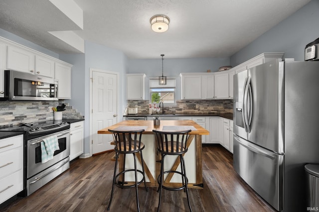 kitchen with stainless steel appliances, a sink, and white cabinets