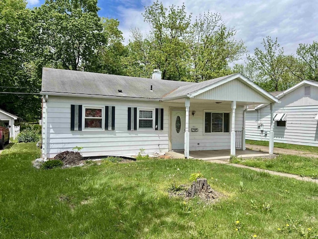 ranch-style home with a chimney and a front lawn