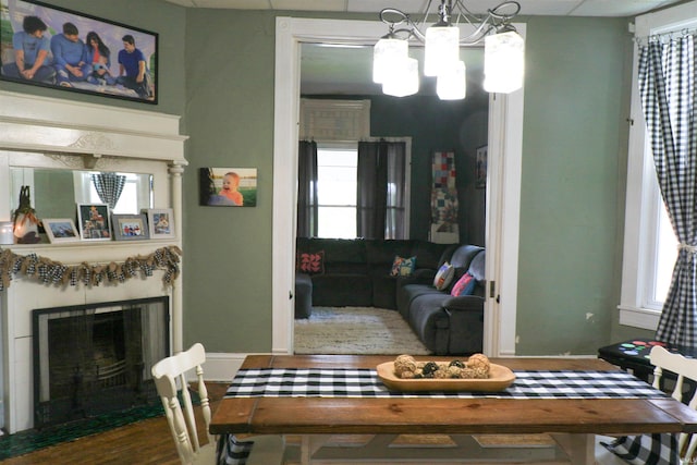 1008 E Walnut St, Petersburg, IN 47567 - dining room featuring a chandelier, baseboards, a fireplace with flush hearth, and healthy amount of natural light