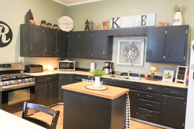 1008 E Walnut St, Petersburg, IN 47567 - kitchen featuring appliances with stainless steel finishes, ornamental molding, a sink, a center island, and wood counters