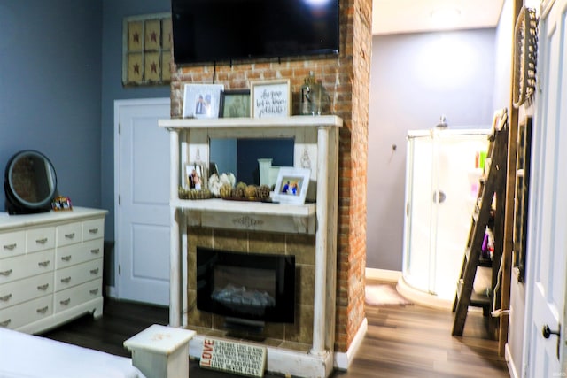 1008 E Walnut St, Petersburg, IN 47567 - bedroom featuring wood finished floors, a tiled fireplace, and baseboards