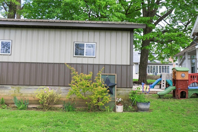 1008 E Walnut St, Petersburg, IN 47567 - view of home's exterior featuring a playground, a yard, metal roof, and board and batten siding
