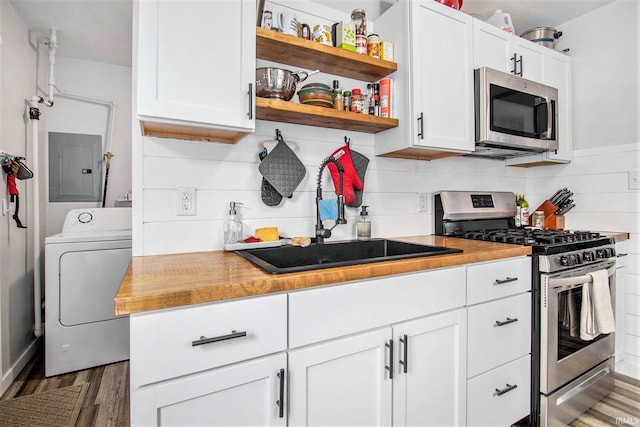 2017 Delaware St, Mishawaka, IN 46544 - kitchen featuring appliances with stainless steel finishes, washer / dryer, electric panel, a sink, and wood finished floors