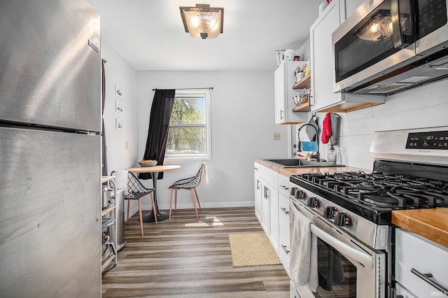 2017 Delaware St, Mishawaka, IN 46544 - kitchen featuring stainless steel appliances, a sink, open shelves, and white cabinetry