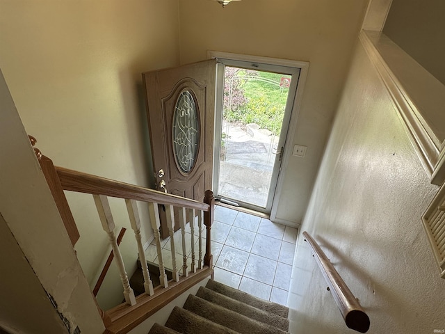 entryway featuring light tile patterned flooring and stairs