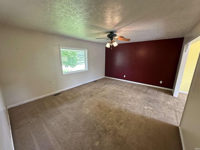 carpeted empty room featuring ceiling fan, baseboards, and a textured ceiling