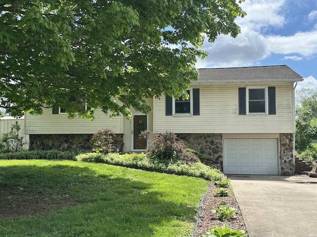 raised ranch with stone siding, concrete driveway, a garage, and a front yard
