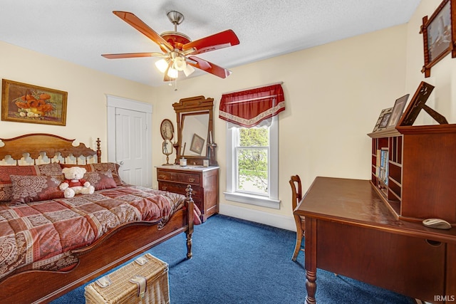 bedroom featuring dark colored carpet, ceiling fan, and a desk