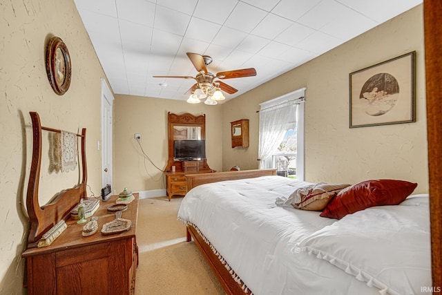 bedroom with light colored carpet and a ceiling fan