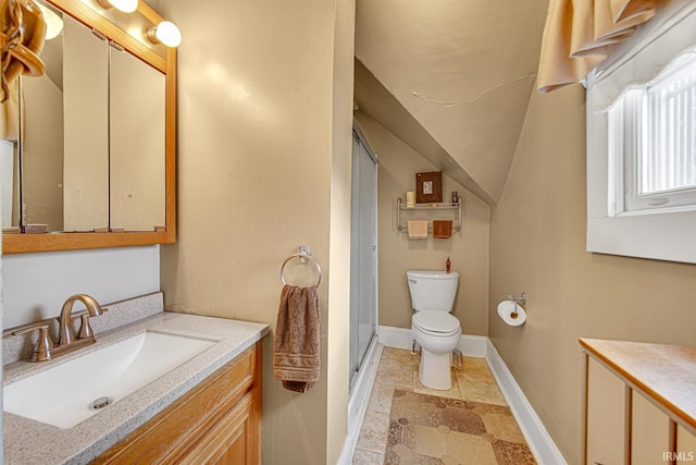 bathroom with vanity, vaulted ceiling, toilet, a shower with door, and baseboards