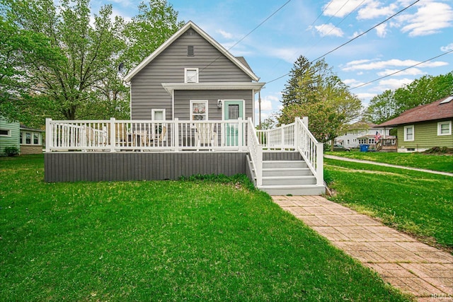 rear view of house featuring a wooden deck and a lawn