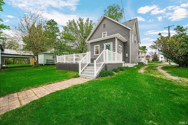 view of front of house with a deck and a front yard