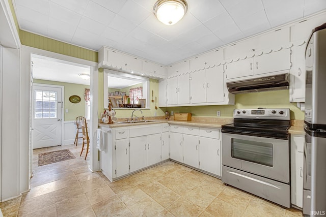 kitchen with appliances with stainless steel finishes, under cabinet range hood, light countertops, white cabinets, and a sink