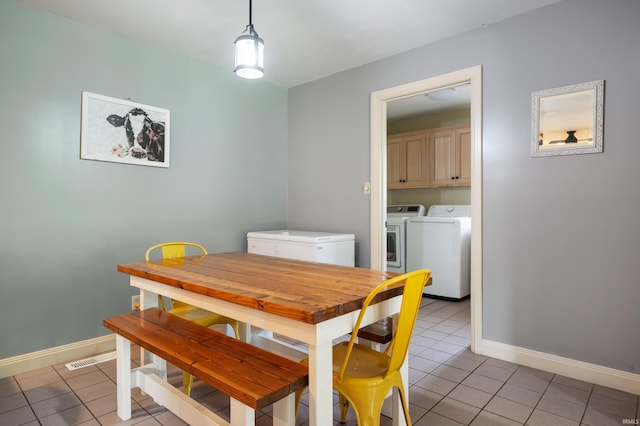 dining space featuring washer and dryer, light tile patterned floors, and baseboards