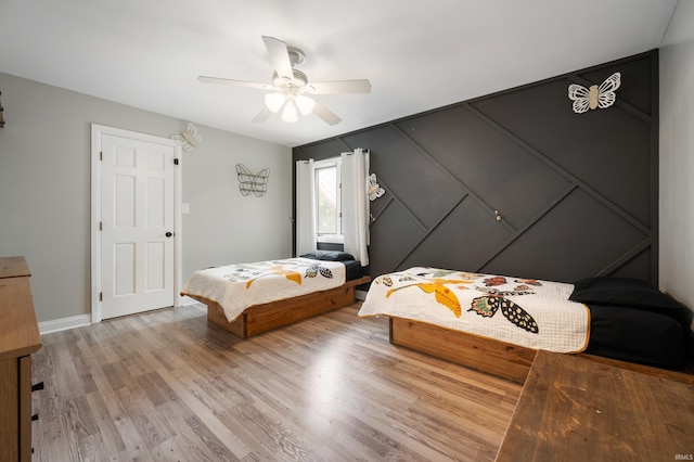 bedroom with light wood-style flooring, ceiling fan, and baseboards