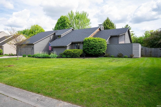 view of side of property featuring roof with shingles, a garage, and a chimney
