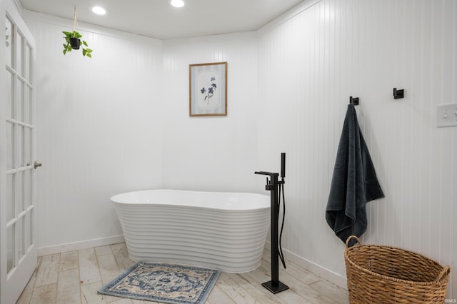 full bathroom with a freestanding tub and recessed lighting