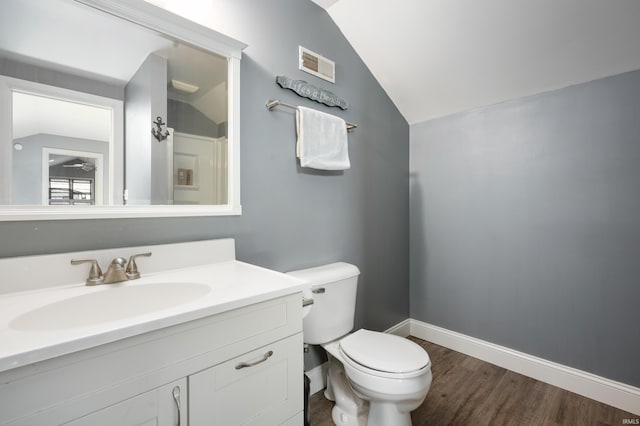 bathroom featuring lofted ceiling, wood finished floors, toilet, baseboards, and vanity