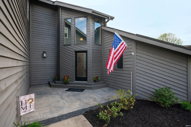 view of exterior entry with a patio area
