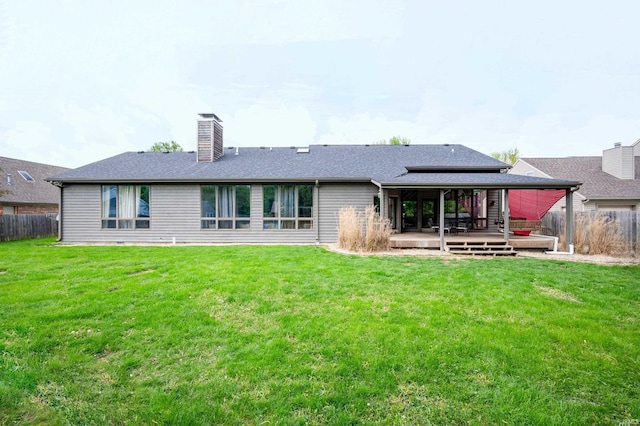 back of house featuring a chimney, a deck, and roof with shingles