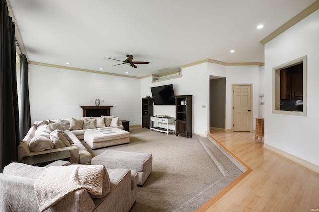 living area featuring a ceiling fan, recessed lighting, light wood-style floors, ornamental molding, and baseboards