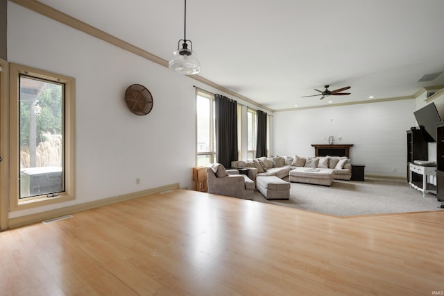 living area featuring a ceiling fan, ornamental molding, wood finished floors, baseboards, and recessed lighting