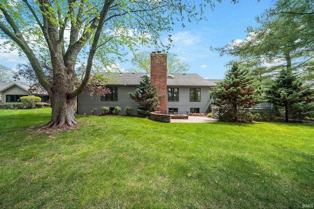 51167 Huntington Ln, Granger, IN 46530 - rear view of house with a patio, a yard, and a chimney