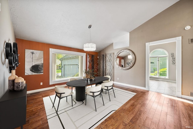 51167 Huntington Ln, Granger, IN 46530 - dining area featuring vaulted ceiling, wood finished floors, baseboards, and a chandelier