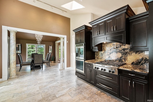 51167 Huntington Ln, Granger, IN 46530 - kitchen featuring appliances with stainless steel finishes, tasteful backsplash, a skylight, baseboards, and light stone countertops