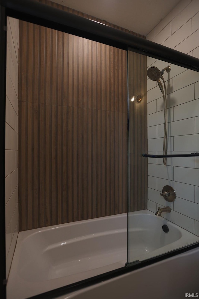 bathroom with bath / shower combo with glass door