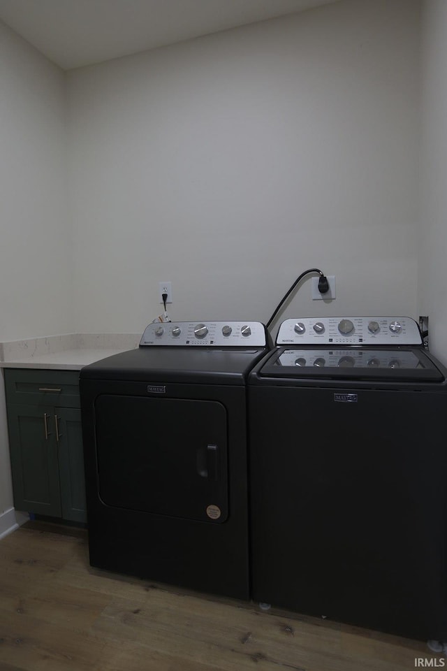 washroom with cabinet space, light wood-style flooring, and washer and dryer