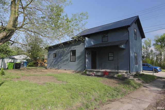 view of front of home with metal roof, a front lawn, and a porch