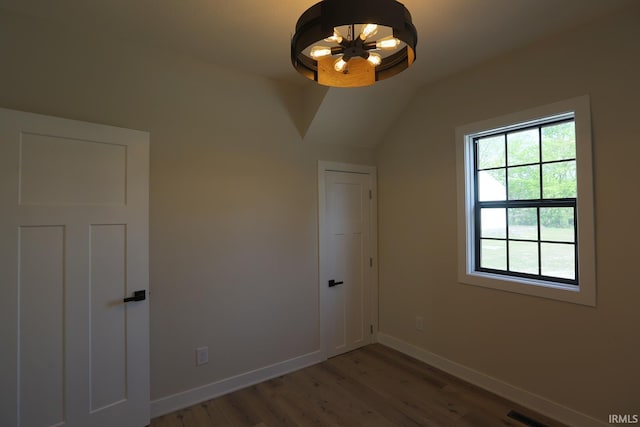 bonus room featuring light wood-type flooring, baseboards, vaulted ceiling, and a chandelier