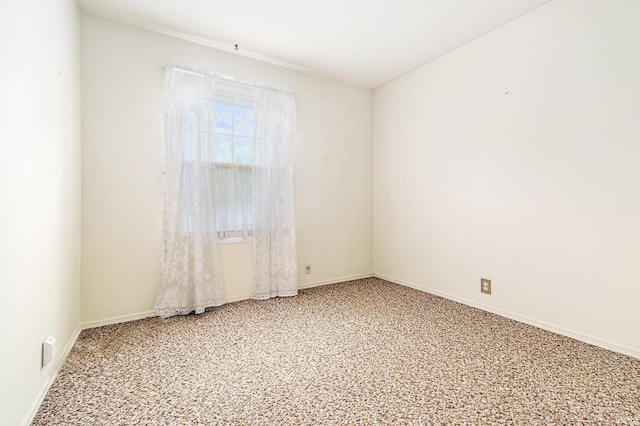 spare room with light colored carpet and baseboards