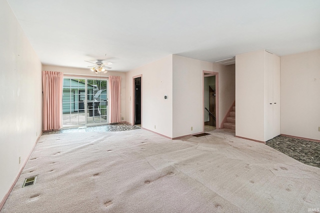 unfurnished living room featuring carpet flooring, stairway, and baseboards