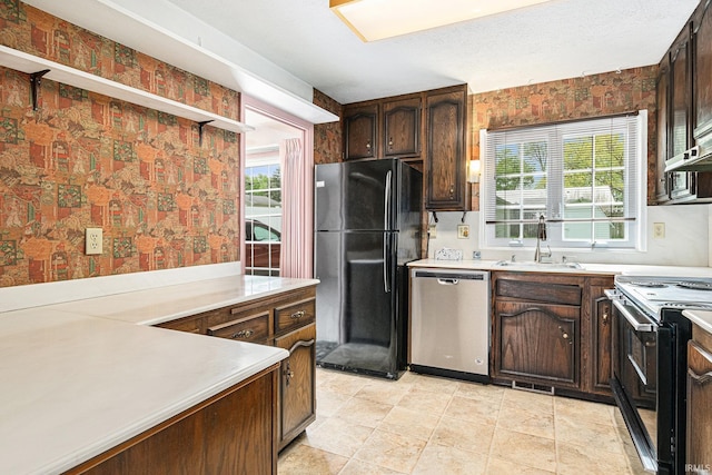 kitchen featuring freestanding refrigerator, dishwasher, a sink, electric stove, and light countertops