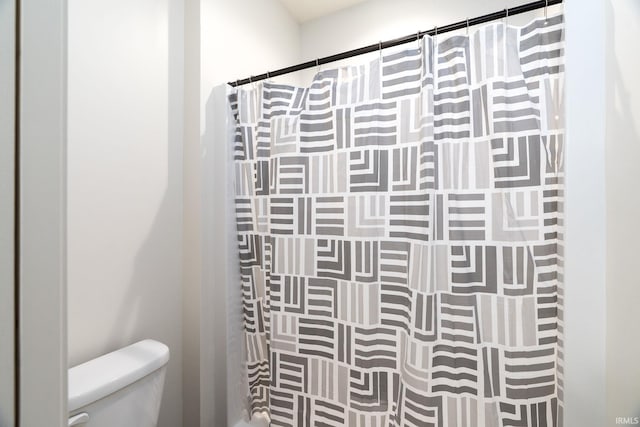 bathroom with toilet and a shower with shower curtain