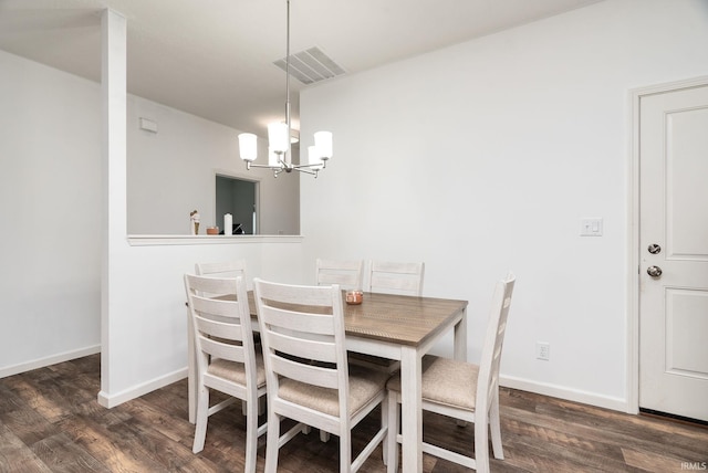 dining room featuring wood finished floors, a chandelier, and baseboards