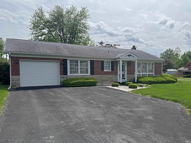 ranch-style house featuring a garage, asphalt driveway, stone siding, a front yard, and brick siding