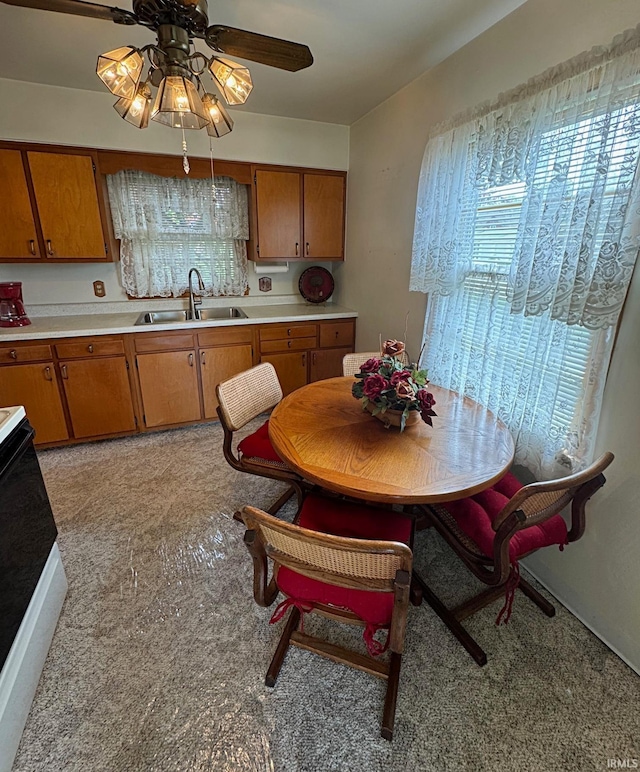 kitchen featuring a sink, ceiling fan, brown cabinetry, and light countertops