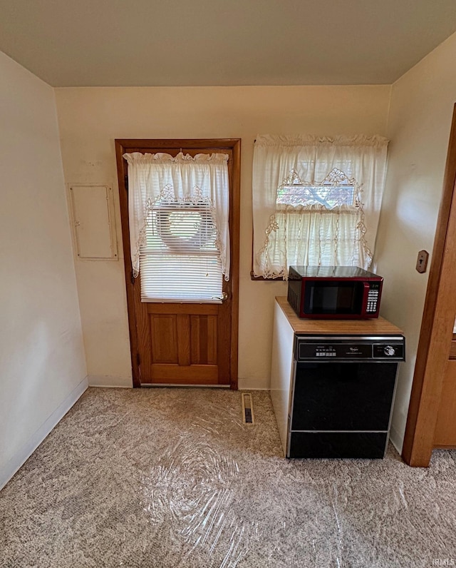 doorway to outside featuring baseboards and light colored carpet
