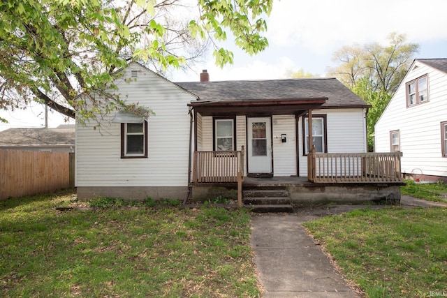 bungalow-style home with a porch, a chimney, and a shingled roof
