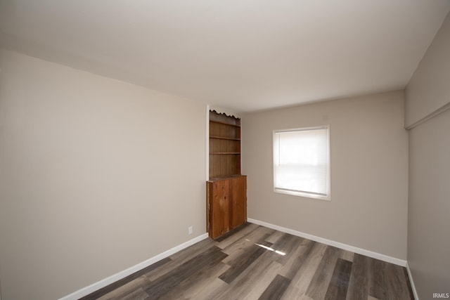 unfurnished room featuring wood finished floors and baseboards