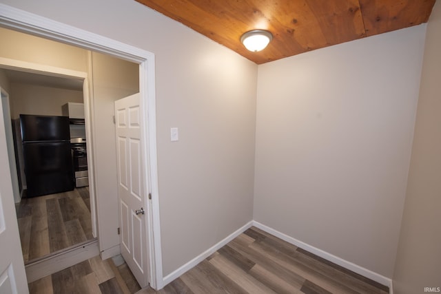hallway featuring wood finished floors, wood ceiling, and baseboards