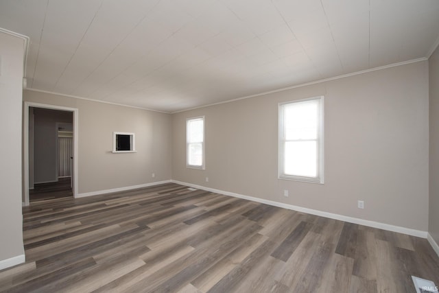 spare room featuring ornamental molding, dark wood finished floors, and baseboards
