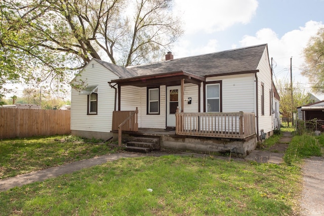 view of front of home with a porch, a chimney, and a shingled roof